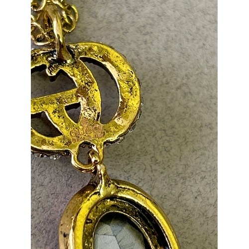 47A - Gucci. Designer double G necklace and matching earring set with large oval cut white crystals and wi... 