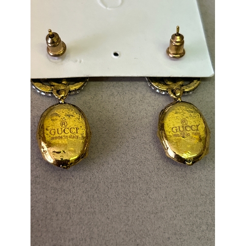 47A - Gucci. Designer double G necklace and matching earring set with large oval cut white crystals and wi... 