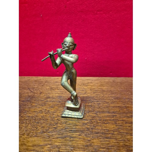 290 - Brass figurine of the Hindu deity Krishna playing the flute. 19cm tall.