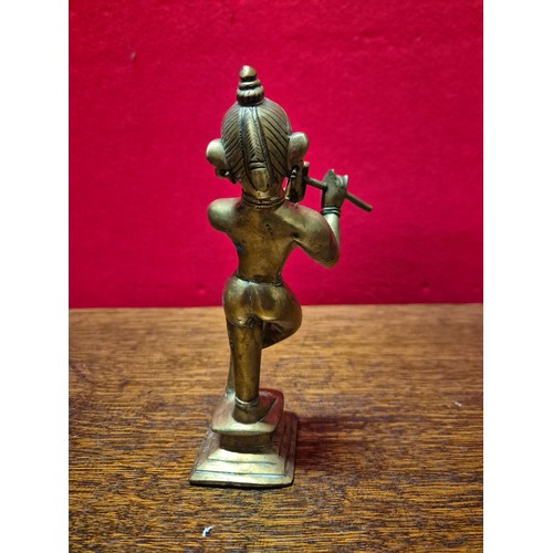 290 - Brass figurine of the Hindu deity Krishna playing the flute. 19cm tall.