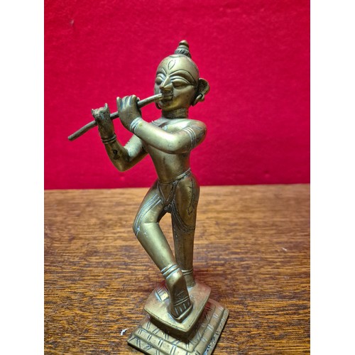 290 - Brass figurine of the Hindu deity Krishna playing the flute. 19cm tall.