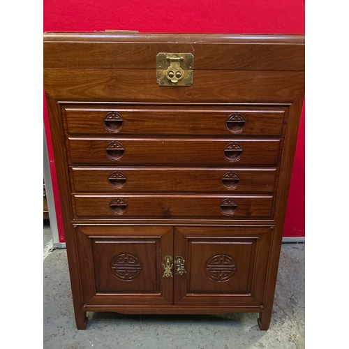 595 - A Chinese hardwood side cabinet with hinged top, four slim drawers and cupboard below. Carved to the... 