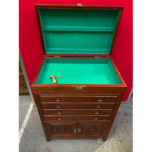 595 - A Chinese hardwood side cabinet with hinged top, four slim drawers and cupboard below. Carved to the... 