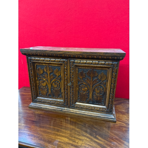 597 - A late 19th small oak cupboard with carved door panels representing the tree of life. Internal shelf... 