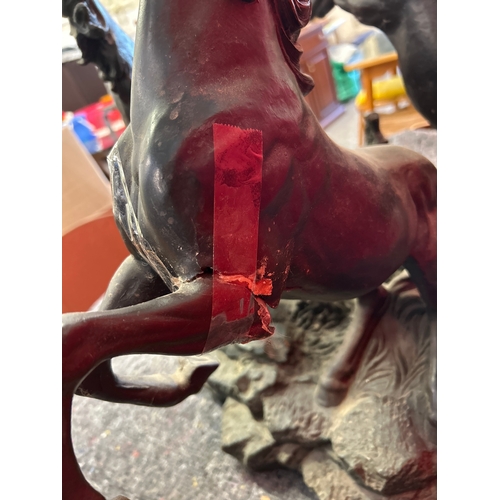 599 - A 20th Century circular glass topped coffee table with the base in the form of three rearing horses.... 