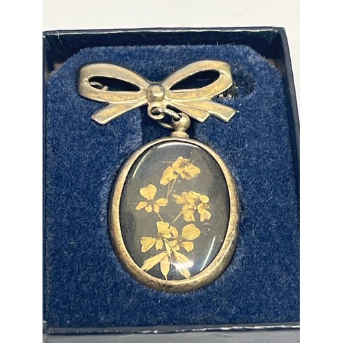 67M - A bronze belt buckle, early 20th century, a brooch of flowers and a lovely parasol in filigree work.