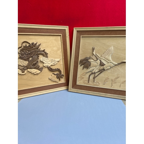 222 - Two Far Eastern carved wood pictures, one of cranes and the other a Chinese dragon. 60cm x 60cm