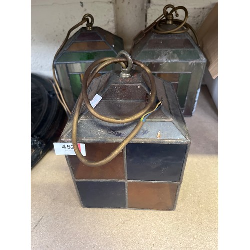 452 - Three early 20thC leaded glass pendant lamp shades, wired to electric with brass fittings and staine... 