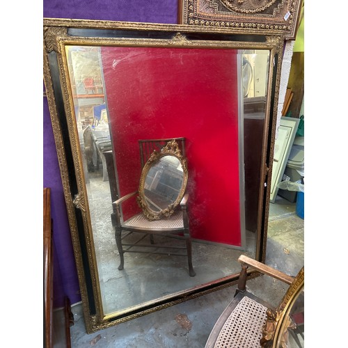 234 - A very large & decorative wall mirror with bevelled glass, the frame with gilt gesso detail against ... 