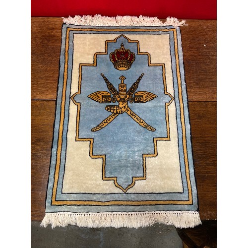 219A - An Omani prayer rug with fringed ends, decorated with the national emblem of the Sultinate of Oman i... 