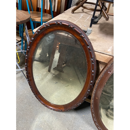 231C - Edwardian oval wall mirror with bevel edged glass and chain carved mahogany frame. 85cm x 59cm