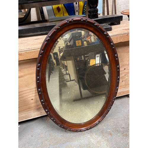231C - Edwardian oval wall mirror with bevel edged glass and chain carved mahogany frame. 85cm x 59cm