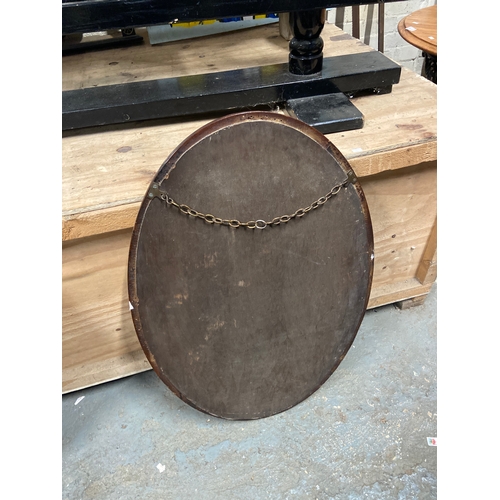 231C - Edwardian oval wall mirror with bevel edged glass and chain carved mahogany frame. 85cm x 59cm