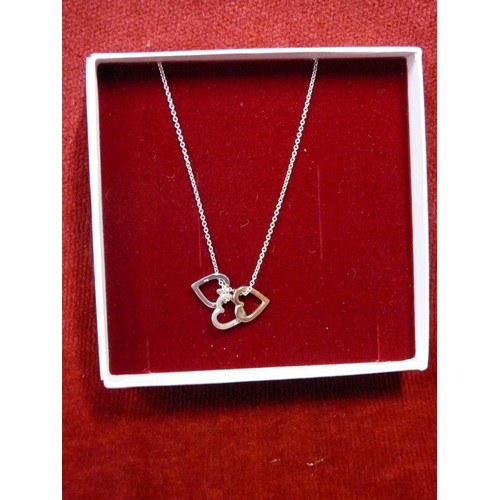 19 - A SOLID SILVER CHAIN WITH 3 HEARTS ON IT