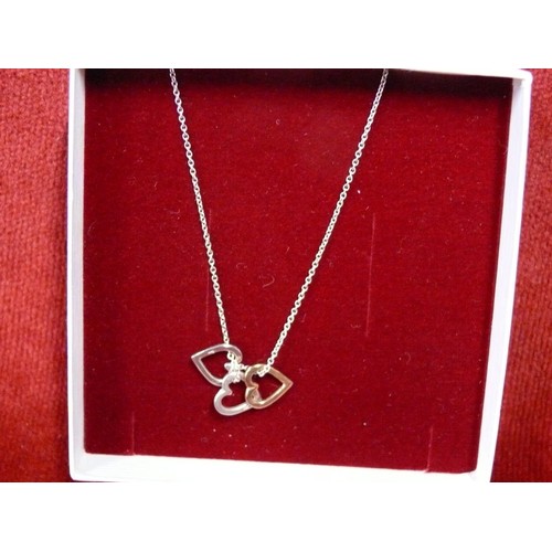 19 - A SOLID SILVER CHAIN WITH 3 HEARTS ON IT