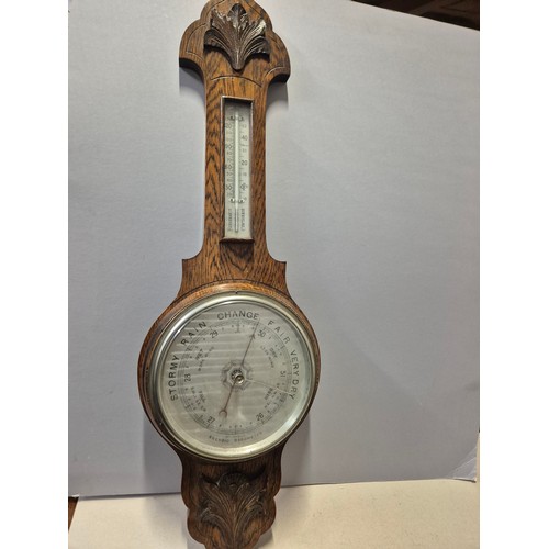 156 - Edwardian aneroid barometer and thermometer in carved oak case, together with another barometer in A... 