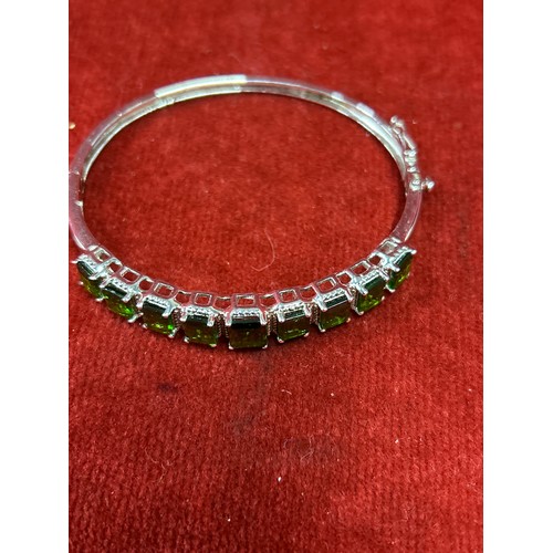 42 - A most attractive sterling silver bracelet set with nine square cut, graduated emerald coloured ston... 