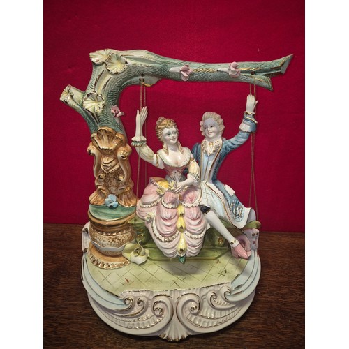 20 - A very large Capodimonte porcelain figurine of a courting couple on a swing. Polychrome and gilt dec... 