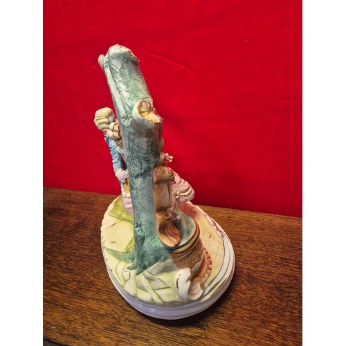 20 - A very large Capodimonte porcelain figurine of a courting couple on a swing. Polychrome and gilt dec... 
