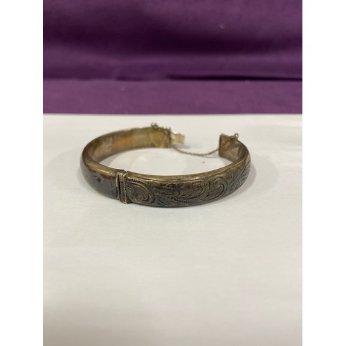 37 - A vintage sterling silver bangle with safety chain, engraved with a scroll design. Birm hallmark, 19... 
