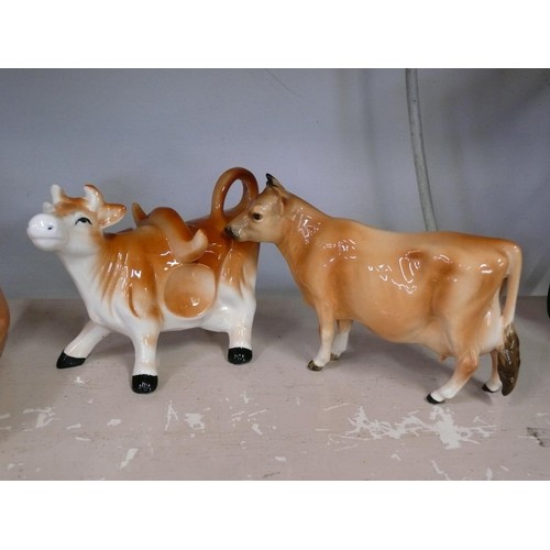 90 - Pair of ceramic cow creamers plus a cow butter dish and a Jersey cruet set