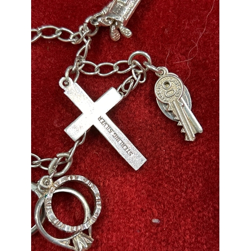 18A - Sterling silver charm bracelet with cross, donkey, keys, miniature rings. 16grams