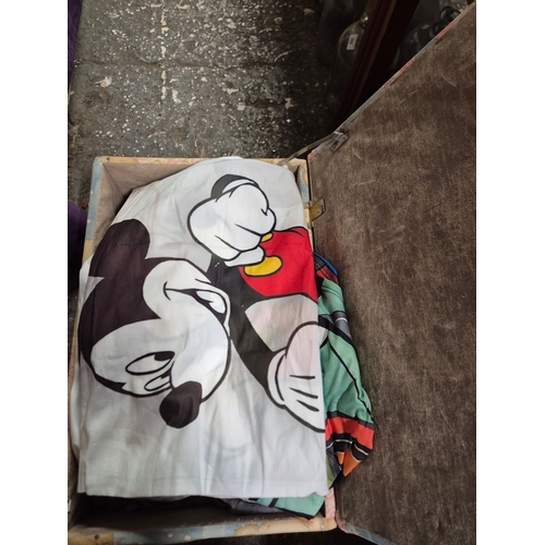 209 - Bear ottoman with contents of Ladies clothing large sizes and bedding including a Mickey Mouse bed s... 