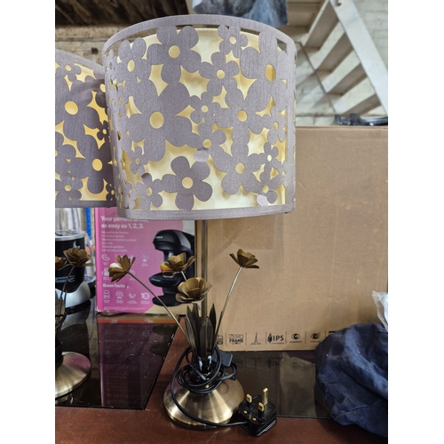 223 - Pair of table lamps with a cut-out floral pattern shades and metal bases with decorative leaves. 