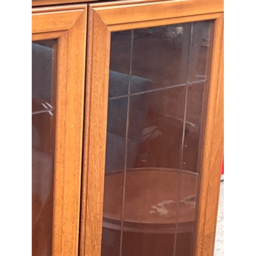 310 - Vintage-style wooden display cabinet with leaded glass doors and ornate metal handles.