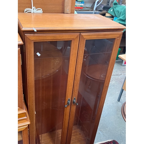 310 - Vintage-style wooden display cabinet with leaded glass doors and ornate metal handles.