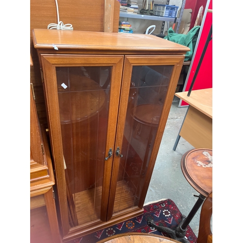 310 - Vintage-style wooden display cabinet with leaded glass doors and ornate metal handles.