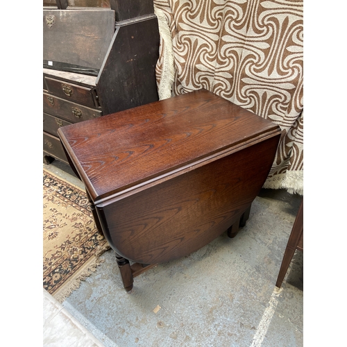 333 - Darkly polished oak drop leaf dining table.