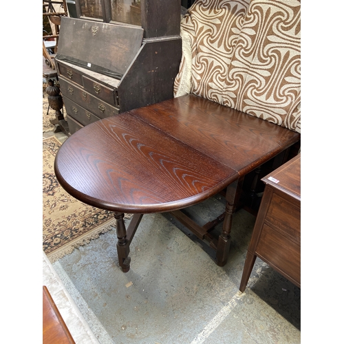 333 - Darkly polished oak drop leaf dining table.
