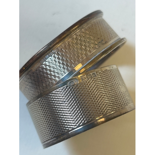 23 - Two sterling silver napkin rings with engine turned engraving, 27.5 grams