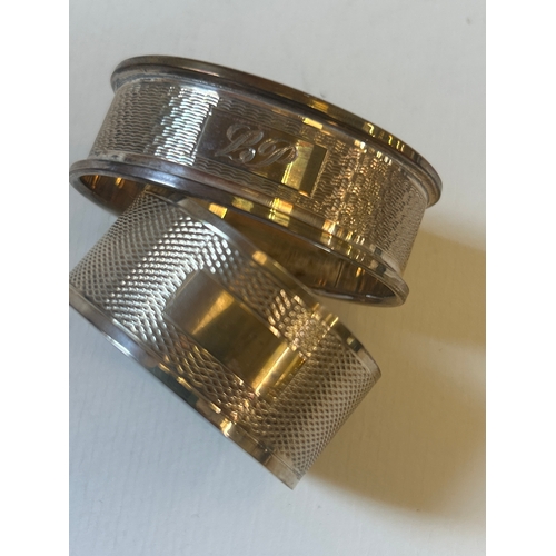 23 - Two sterling silver napkin rings with engine turned engraving, 27.5 grams