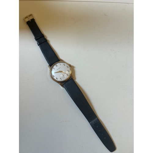 27 - 9ct gold wrist watch by Garrard on leather strap, working when lotted. Presentation inscription to b... 