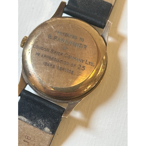 27 - 9ct gold wrist watch by Garrard on leather strap, working when lotted. Presentation inscription to b... 