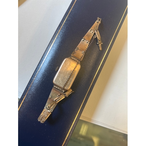 28 - An Art Deco 14ct gold wrist watch with arabic numerals, gold plated strap. Winds & stops & s... 
