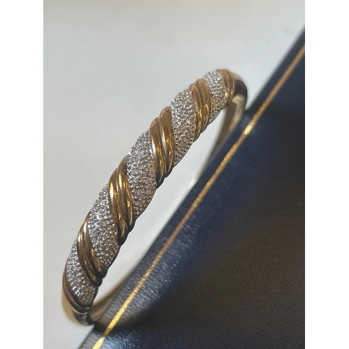 29 - 9ct gold bracelet set with diamond chips in a spiral design. 12.7 grams. Slightly misshapen but catc... 