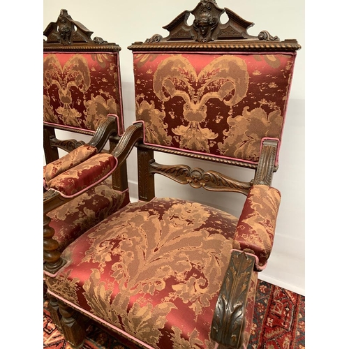 195 - A pair of antique carved arm chairs with oak leaf design, upholstered with burgundy damask