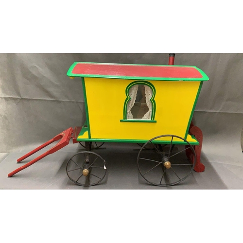 29 - A rare antique toy gypsy caravan with cast iron wheels, measures 54cm long and 53cm high