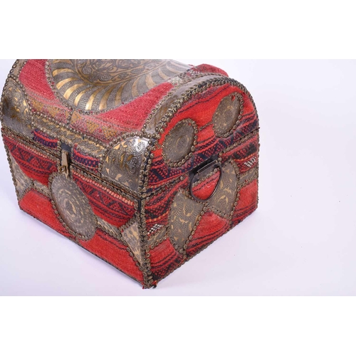 100 - A small middle eastern dome top trunk, 20th century, upholstered in carpet with applied copper studs... 