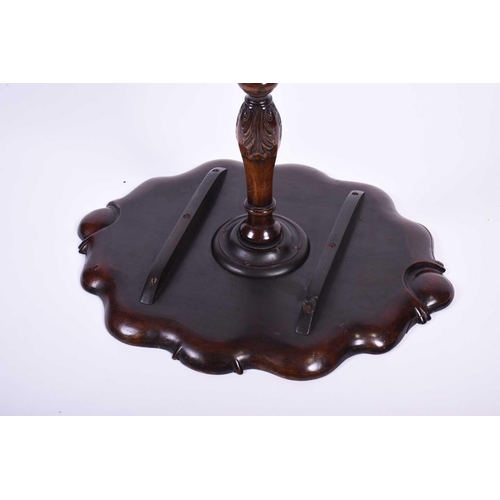 115 - An early 20th century Geo III mahogany tripod table, the shaped top with shell and scroll borders, o... 