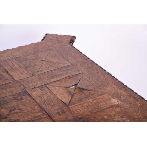 116 - An oak parquetry top table, 19th century, the square top with pronounced corners, the edge with appl... 