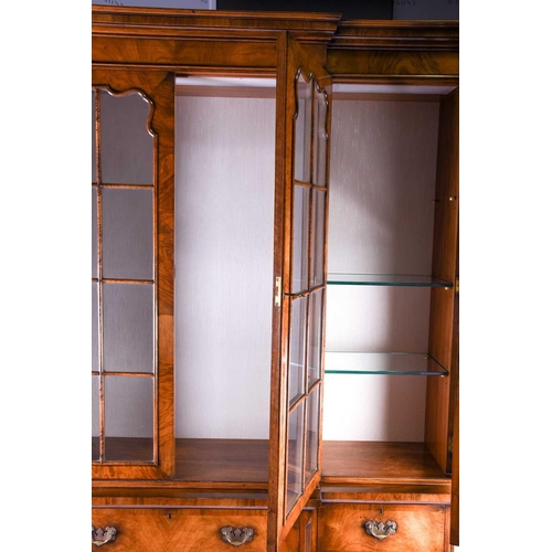 119 - A reproduction Georgian style walnut breakfront display cabinet, the glazed upper section with glass... 