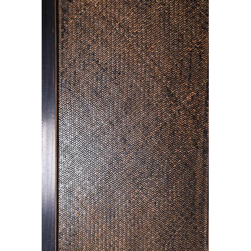 132 - A four fold room divider/screen, with ebonised frame enclosing woven wicker panels, with brass cappe... 