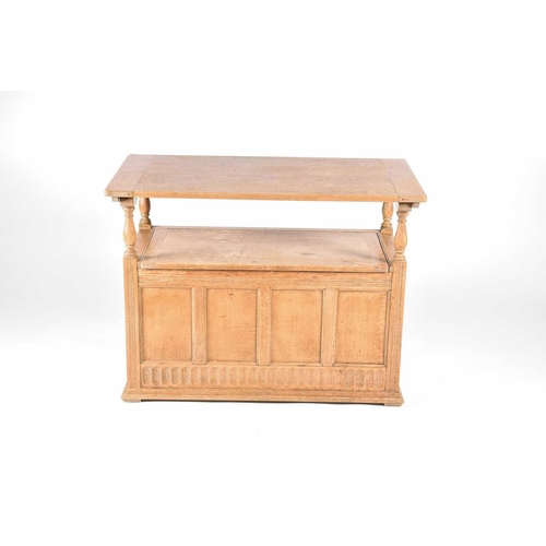 137 - A light oak monks bench, early 20th century, the plain flat top with carved rosettes and fluted pill... 