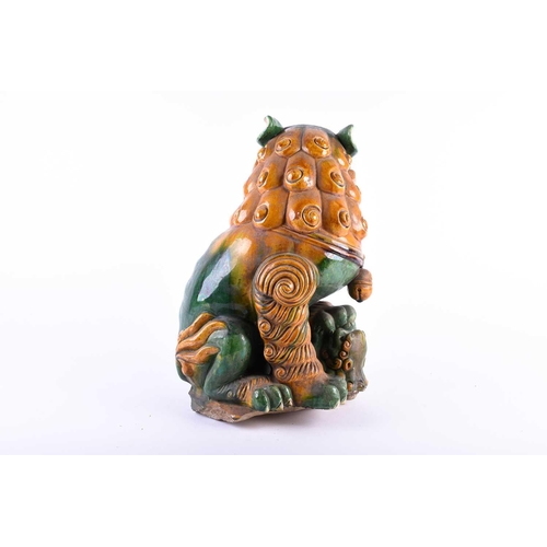 160 - A large Chinese sancai glaze temple lion, Qing, 19th century, a bell hanging from its neck, a small ... 