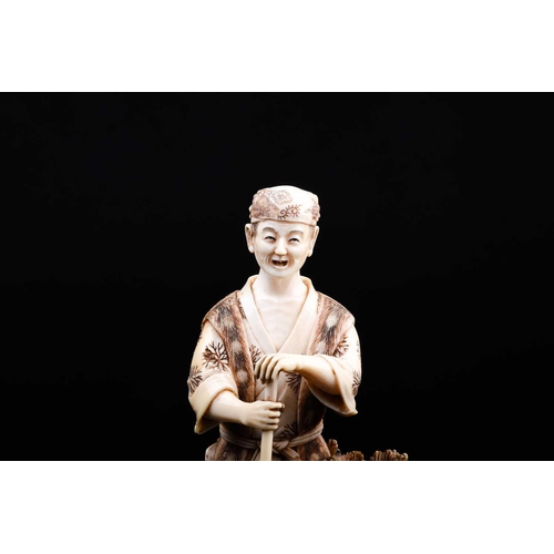 162 - A Japanese ivory okimono of a farmer, Meiji period, the figure modelled standing holding a large rak... 