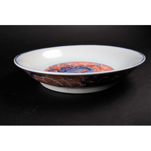 176 - A Chinese dragon plate, of dished form, the centre painted with an Imperial dragon writhing amongst ... 